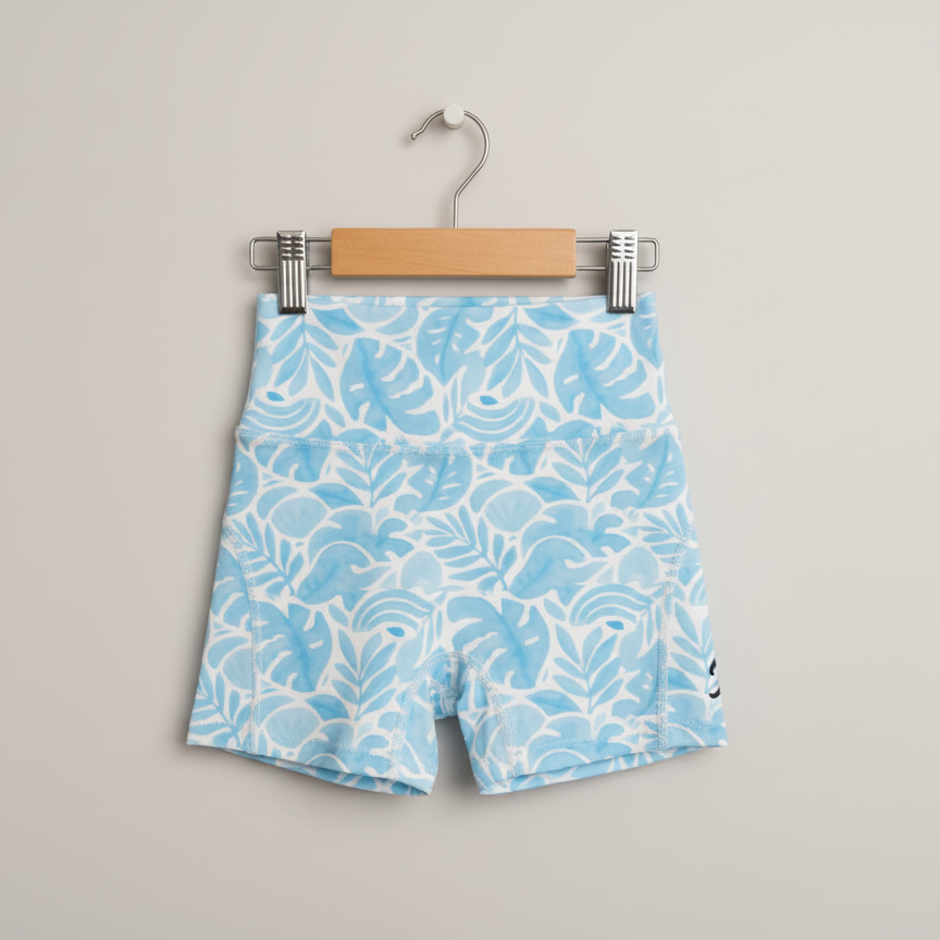Blue shorts with white pattern on a hanger against a gray background