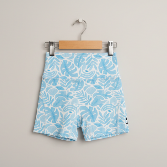 Blue shorts with white pattern on a hanger against a gray background
